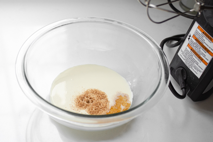 Placing the ingredients for the nutmeg whipped cream in a mixing bowl.