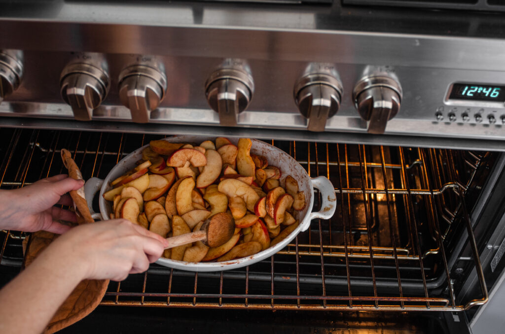 Stirring the baked cinnamon apples while they're baking,