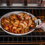 Testing the apple slices for doneness with a fork.