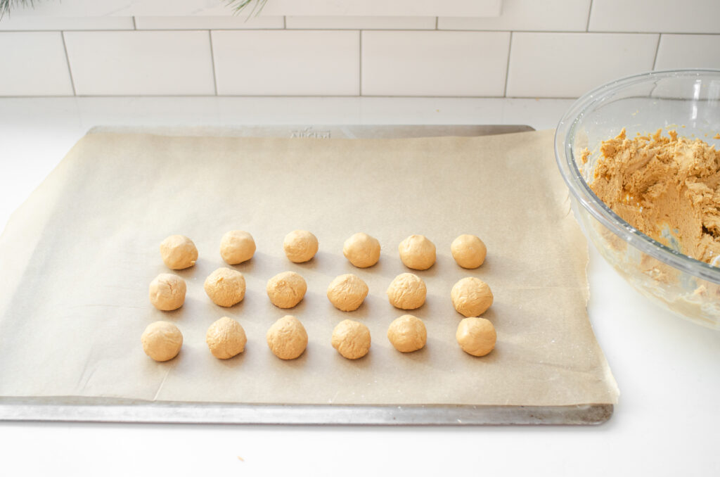 Rolling out the balls of peanut butter dough to make buckeyes without shortening. 