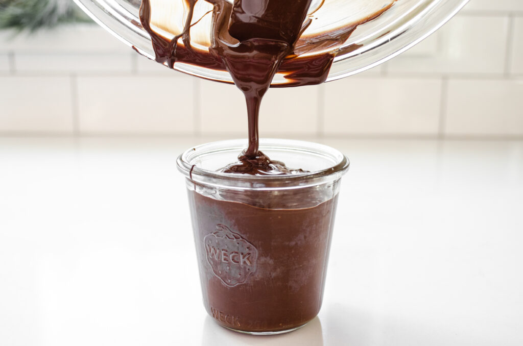 Pouring the chocolate into a glass for dipping the buckeyes. 