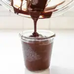 Pouring the chocolate into a glass for dipping the buckeyes.