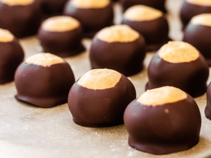 Buckeye recipe without shortening all lined up on a parchment lined baking tray.