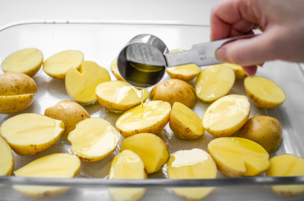 Pouring the EVOO over the little Yukon gold potatoes. 