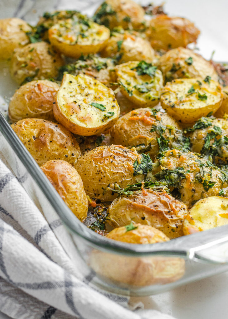 A pan of roasted little potatoes with garlic, lemon, rosemary, parsley, and parmesan cheese. 