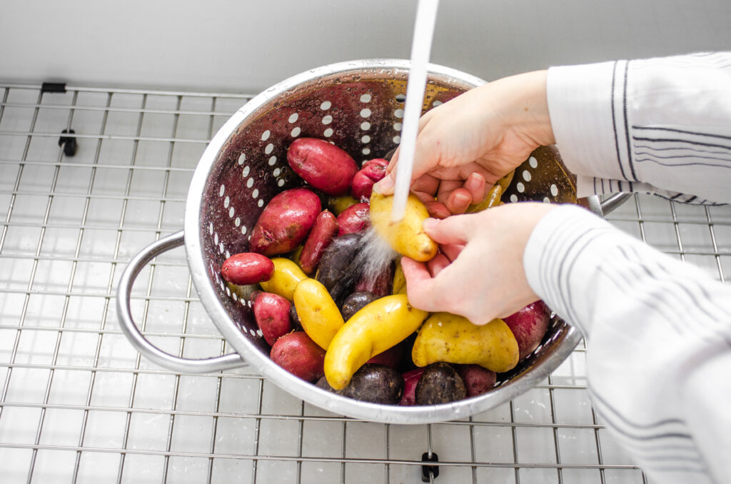 Washing the little potatoes in preparation for roasting in the oven.