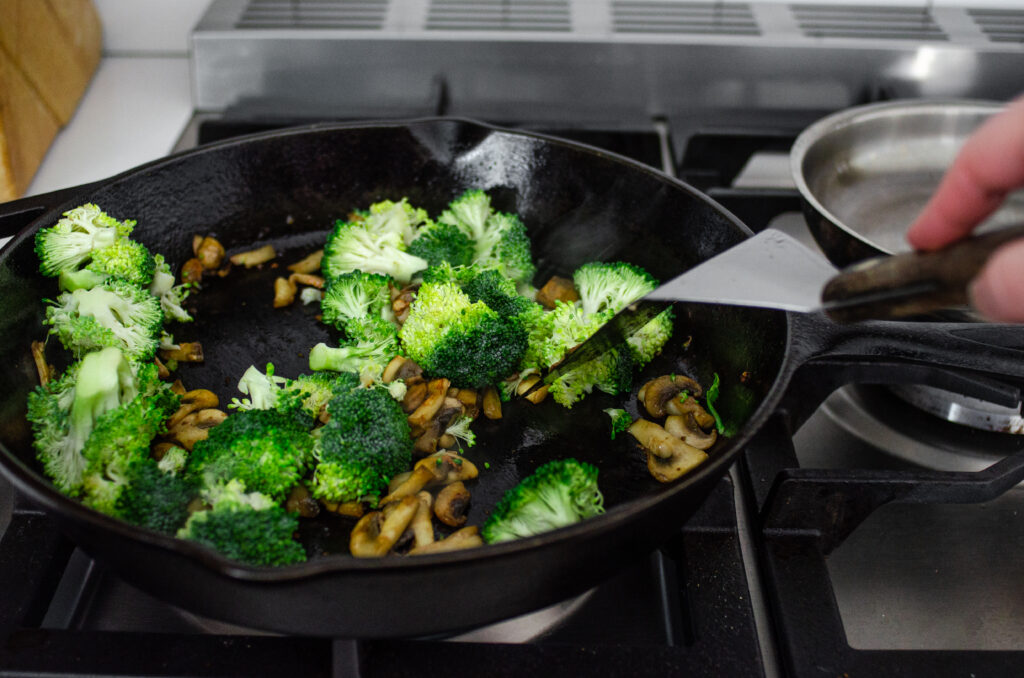 Adding the broccoli florets to the skill to sauté. 