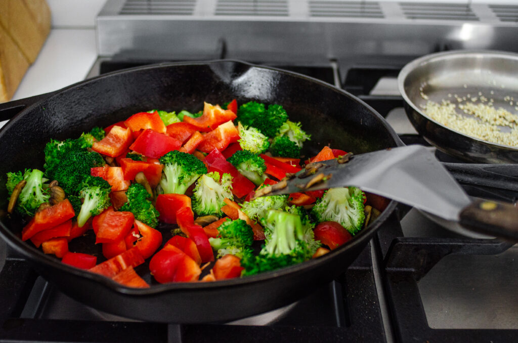 Adding the red bell peppers to the stir fry. 