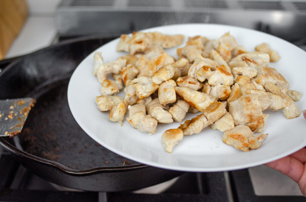 removing the cooked chicken to a plate. 