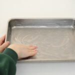 Greasing a 13x9 inch baking dish with coconut oil.