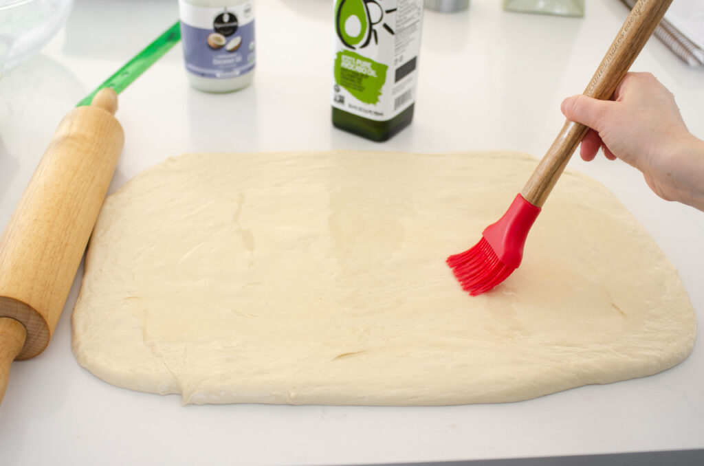 Brushing the dough with the oil in preparation for the filling.