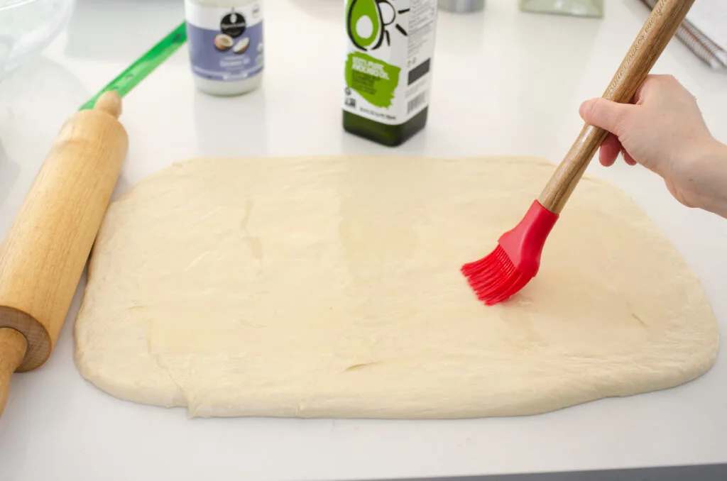 Brushing the dough with the oil in preparation for the filling.