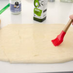 Brushing the dough with the oil in preparation for the filling.