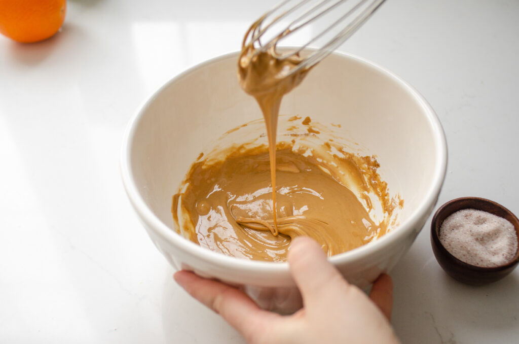 Whisking together the frosting for the cinnamon rolls without milk.