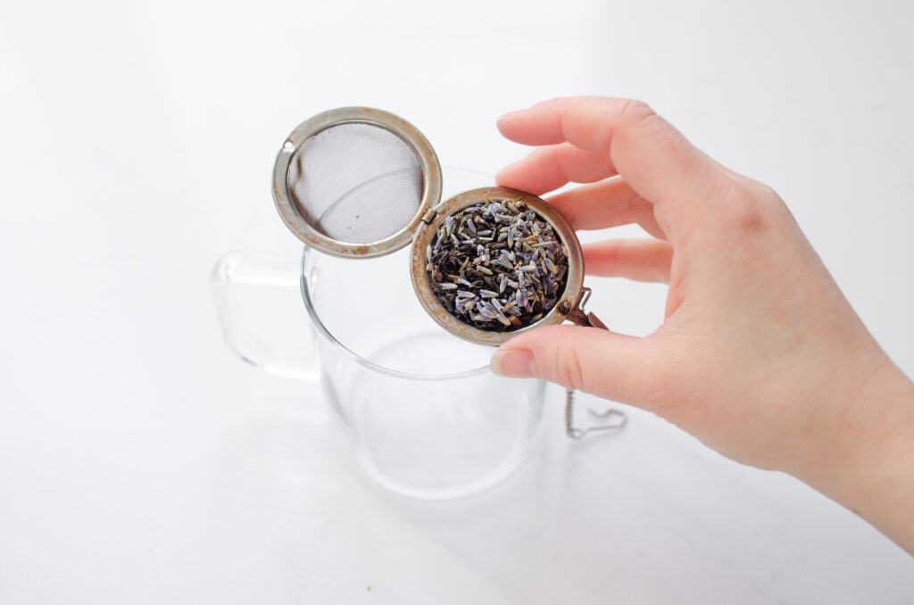 Adding the earl grey tea and lavender to a tea strainer. 