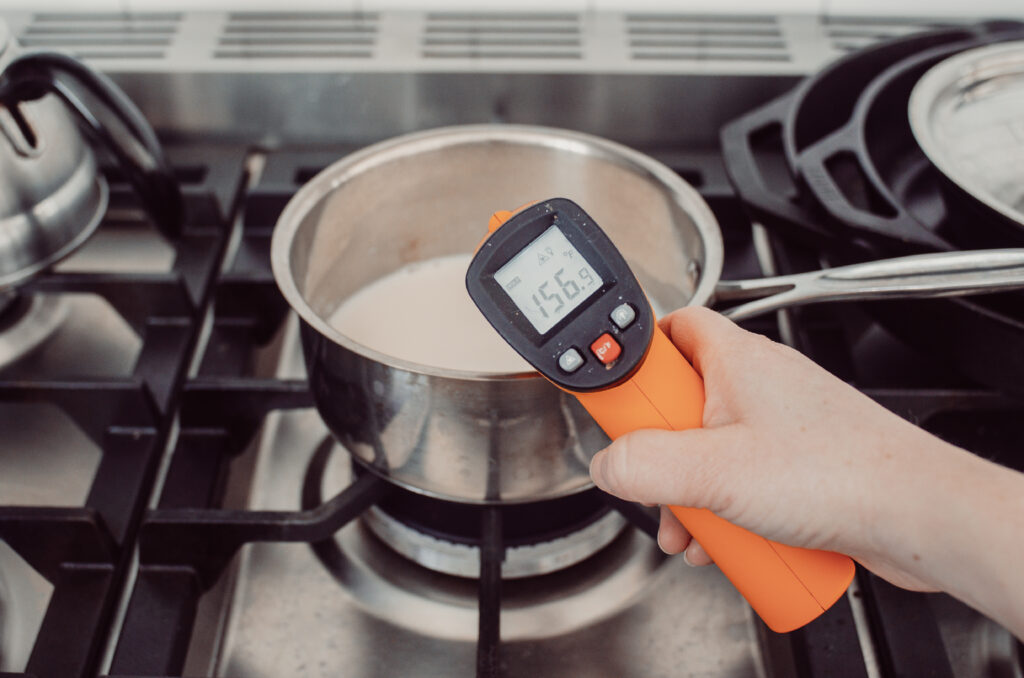 Heating the milk and cream in a pan and checking the temperature with a laser thermometer. 