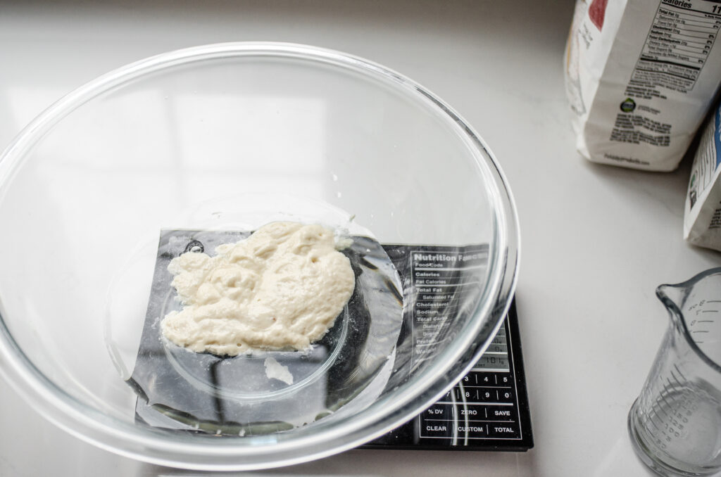 Placing the water and sourdough starter in a large mixing bowl.