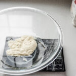 Placing the water and sourdough starter in a large mixing bowl.