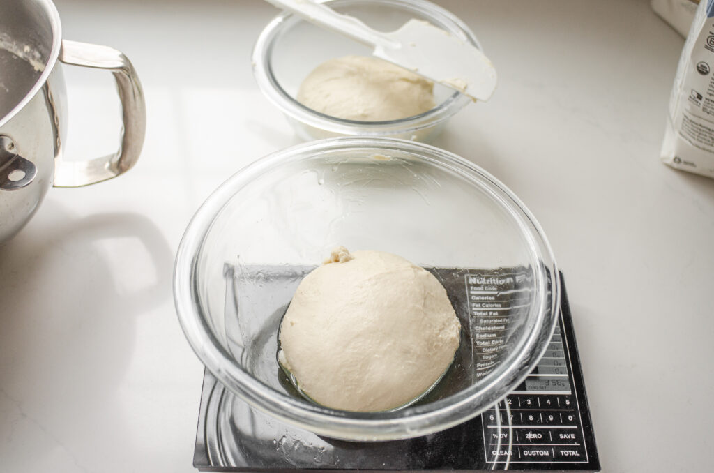 Dividing the sourdough pizza crust into two equal balls.