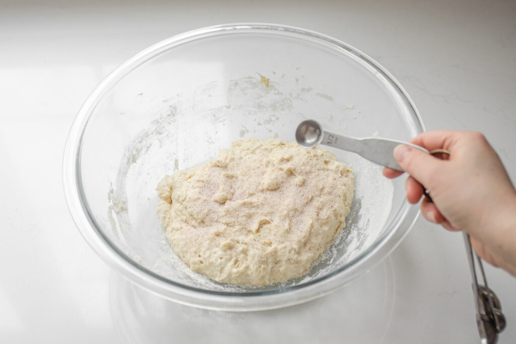 Adding the salt to the sourdough pizza dough.