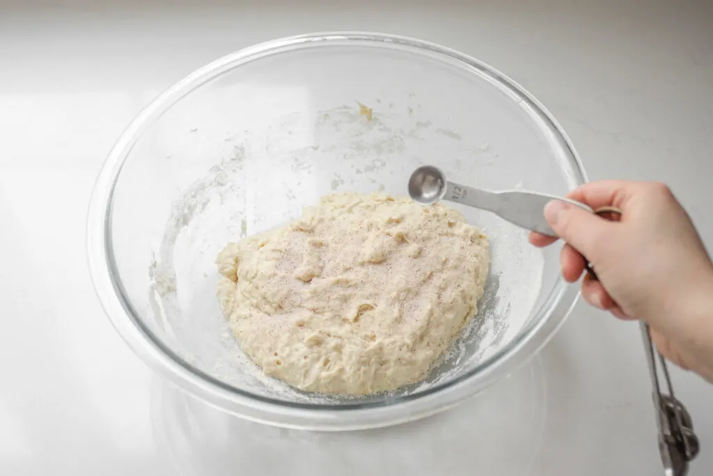 Adding the salt to the sourdough pizza dough.