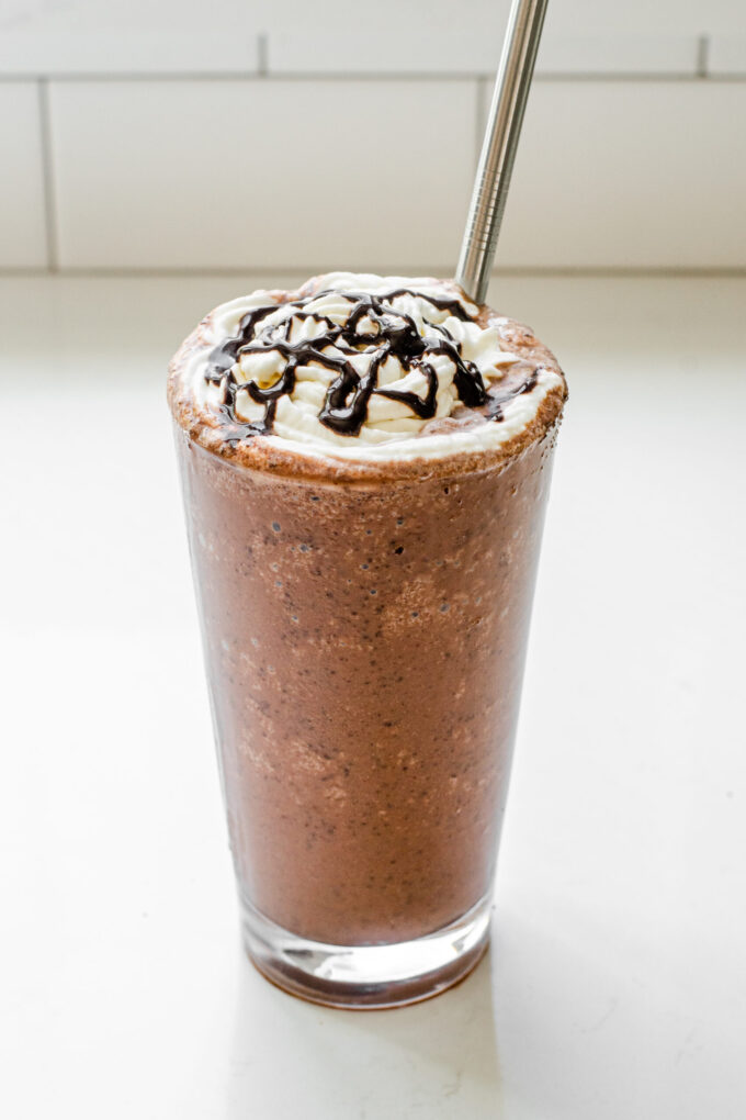 A 16 ounce glass of my copycat Starbucks Double Chocolate Chip Frappuccino recipe with a stainless steel straw.