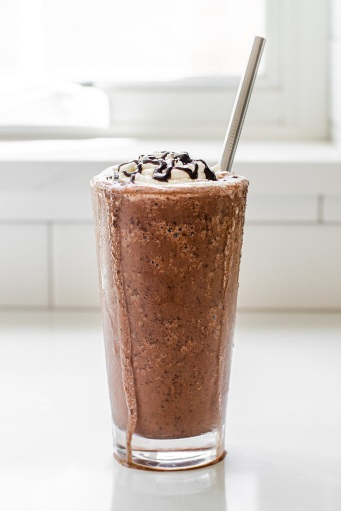 A copycat Starbucks double chocolate chip frappuccino in a 16 ounce glass with a stainless steel straw.