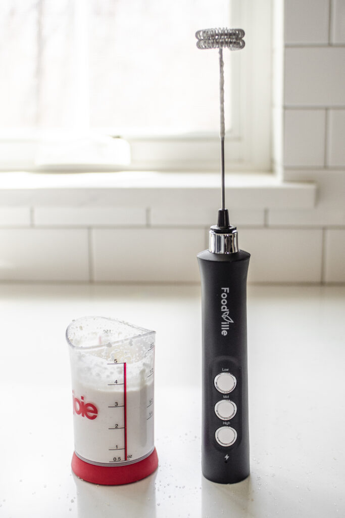 Whipping cream with a hand held milk frother.