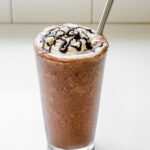 A copycat Starbucks double chocolate chip frappuccino in a 16 ounce glass with a stainless steel straw.