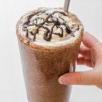 A copycat Starbucks double chocolate chip frappuccino in a 16 ounce glass with a stainless steel straw.