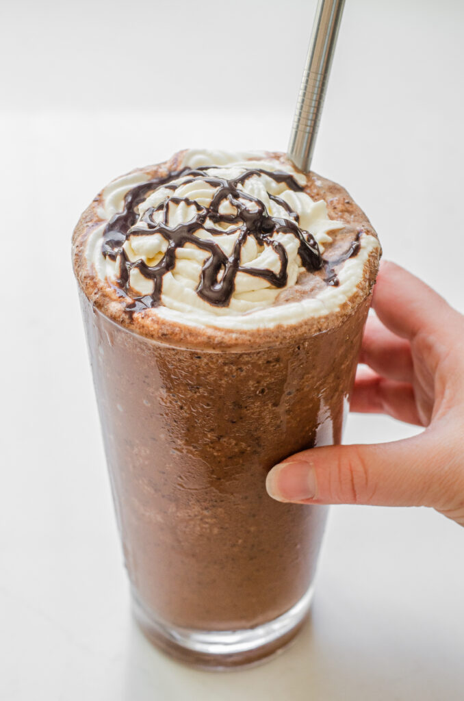 A copycat Starbucks double chocolate chip frappuccino in a 16 ounce glass with a stainless steel straw.