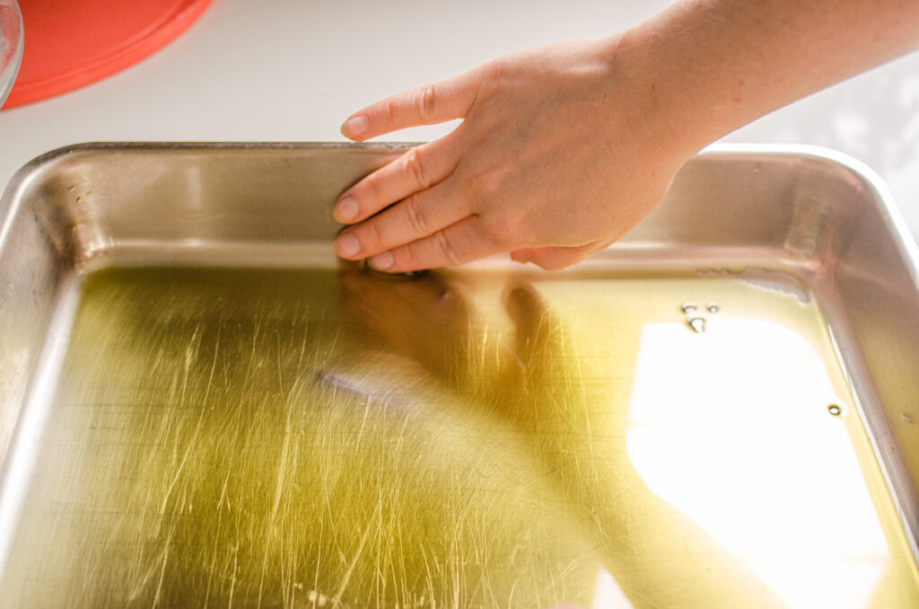 Spreading the olive oil on the side of the pan.