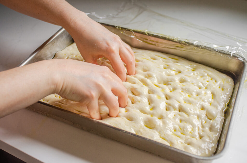 Dimpling the sourdough focaccia dough.