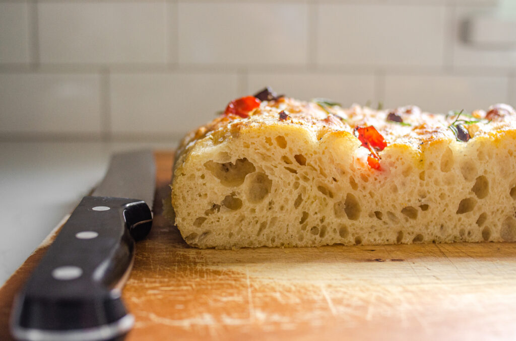 A side shot of a sliced piece of sourdough focaccia so you can see the open crumb.