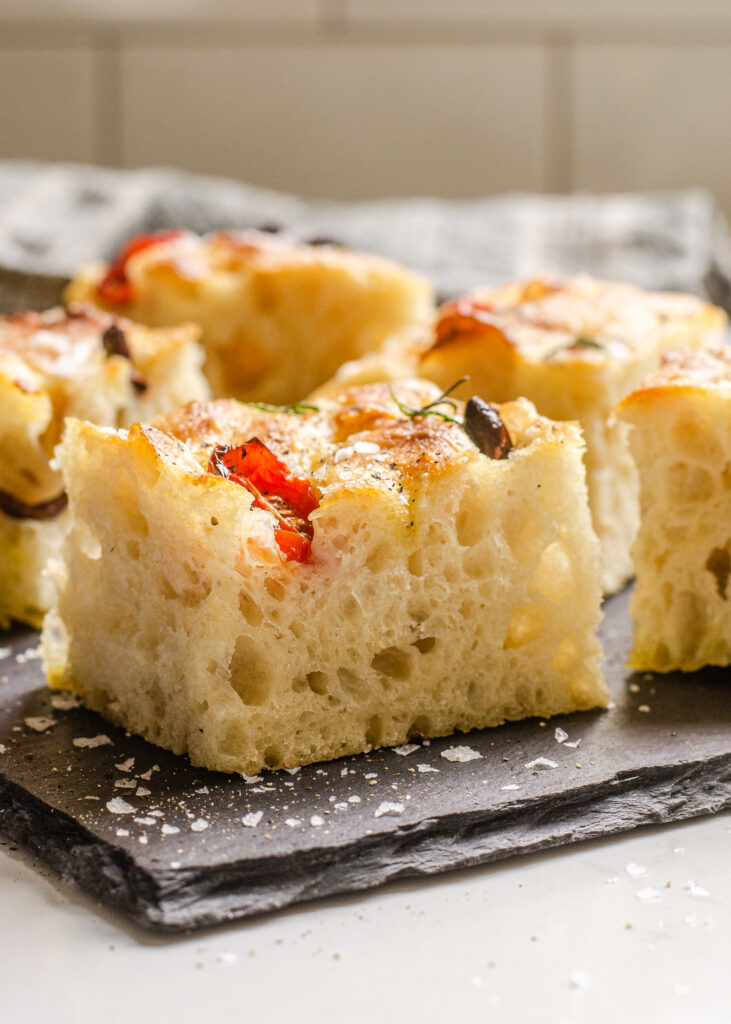 A side shot of a sliced piece of sourdough focaccia so you can see the open crumb.