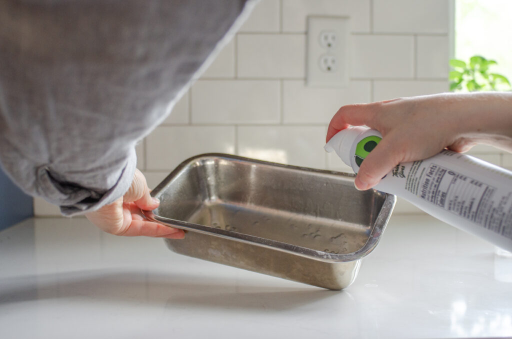 Spraying a pan with cooking oil spray.