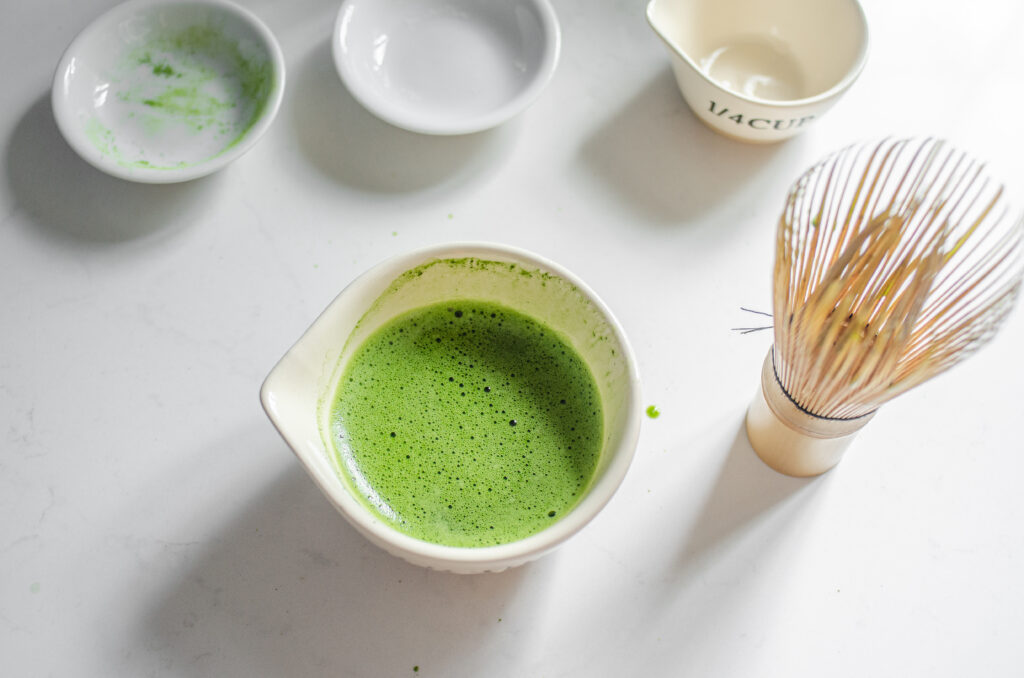 A bowl of whisked matcha, sugar, and water ready to be make into a Starbucks hot matcha green tea latte.