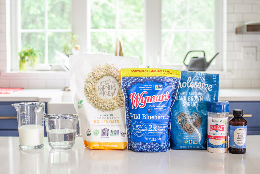 All of the ingredients needed to make blueberry oatmeal laid out on a white countertop.