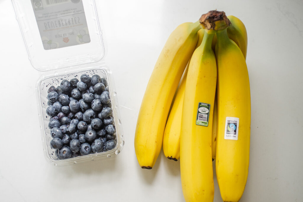 Blueberries and bananas on a white countertop.