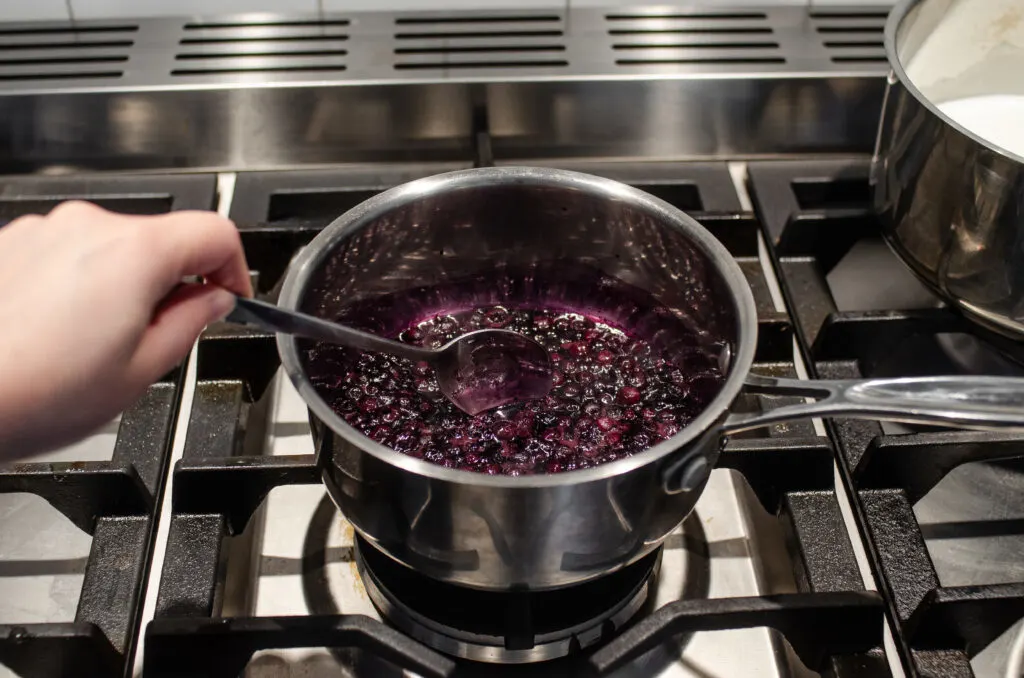 Making a compote with the blueberries and sweetener.