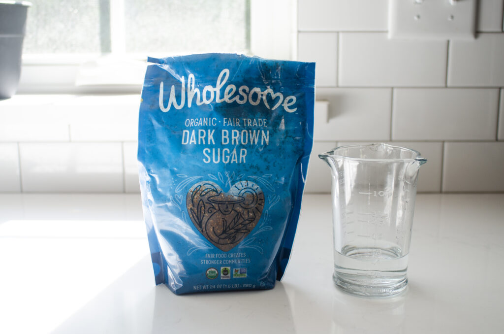 Brown sugar and water on a white countertop. 