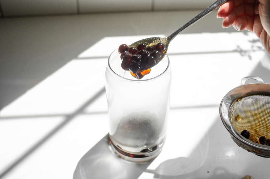 Placing the cooked tapioca pearls into a glass.