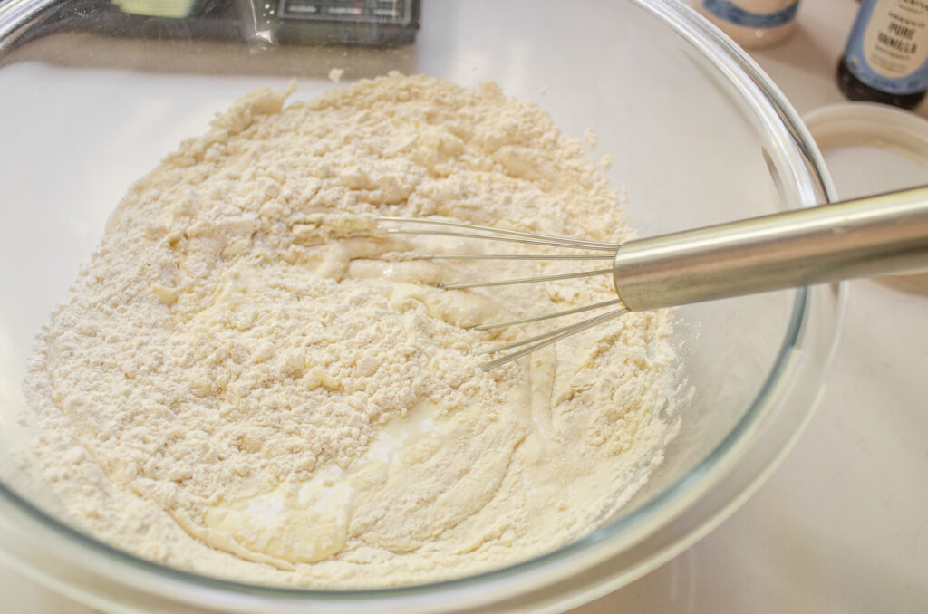 Mixing together the starter with the flour, buttermilk, and sugar. 