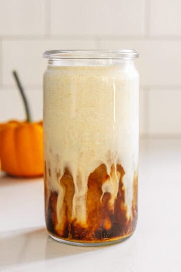 A glass of pumpkin cream cold brew with pumpkin cold foam.