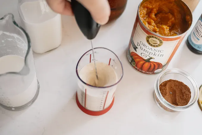 Making the pumpkin cold foam in a small measuring cup.