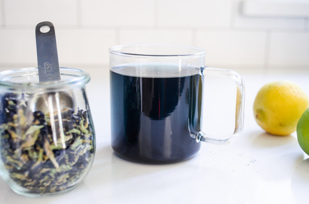 A mug of hot blue butterfly pea flower tea.