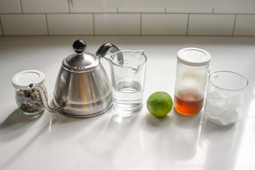 All of the ingredients needed to make an iced butterfly pea tea drink!