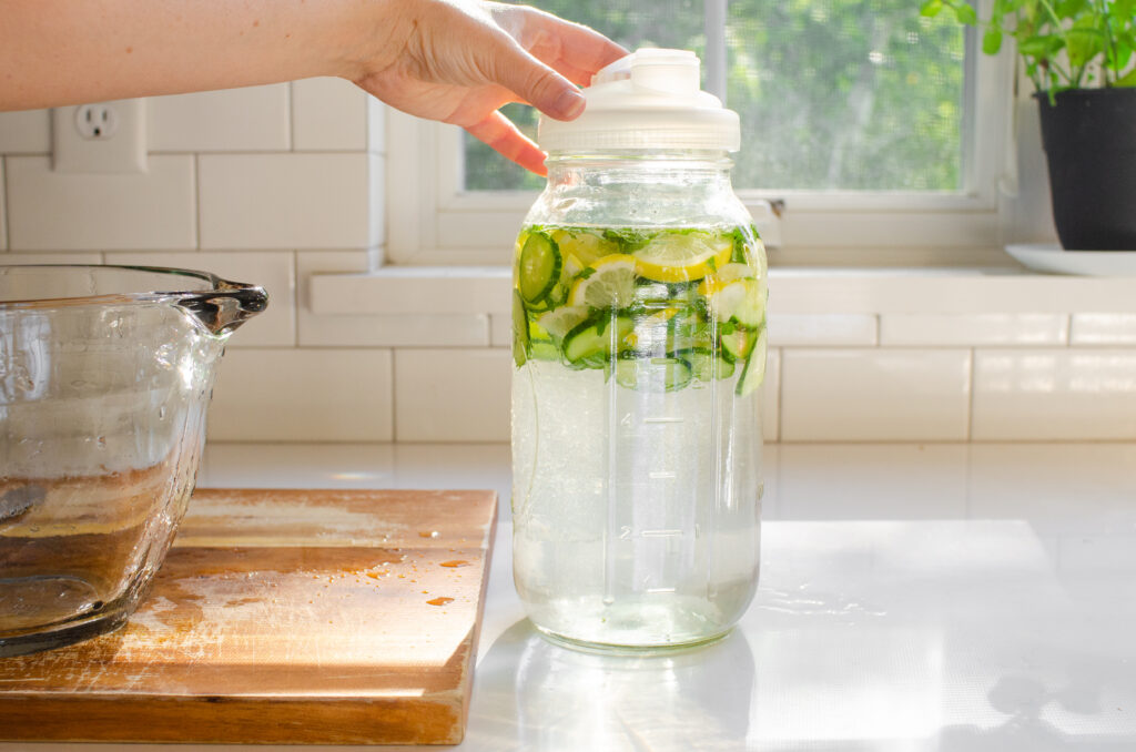 Putting a lid on the jar of cucumber water.