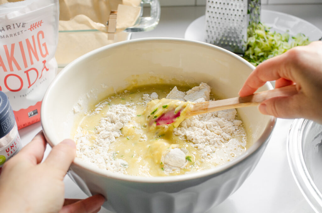 Folding together the wet and dry ingredients.