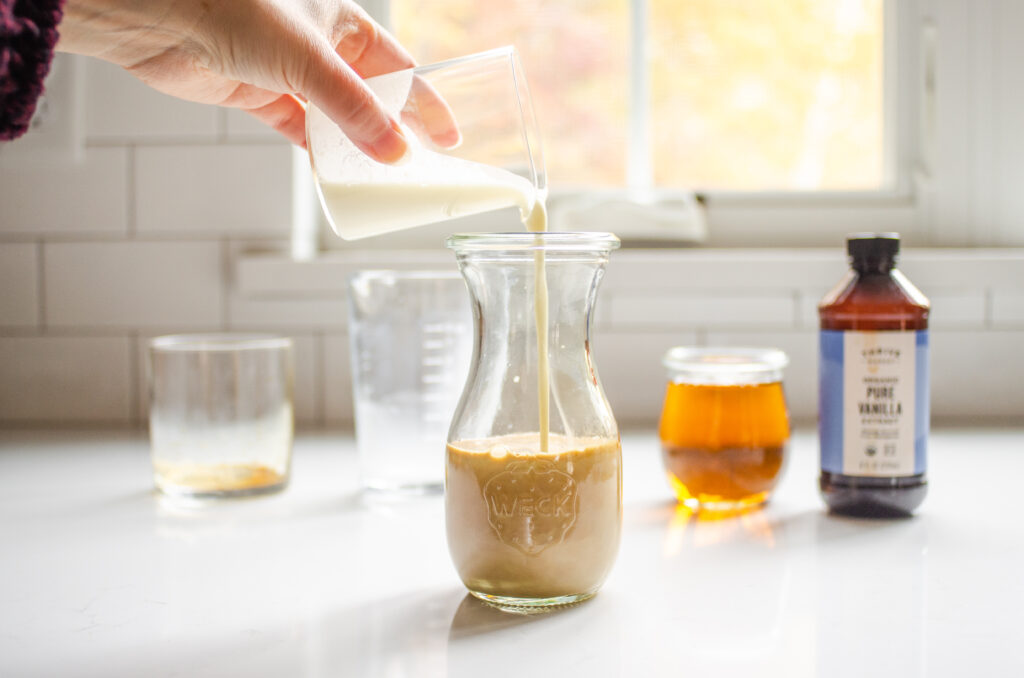 Pouring the cream into the jar to make the bottled frappuccino. 